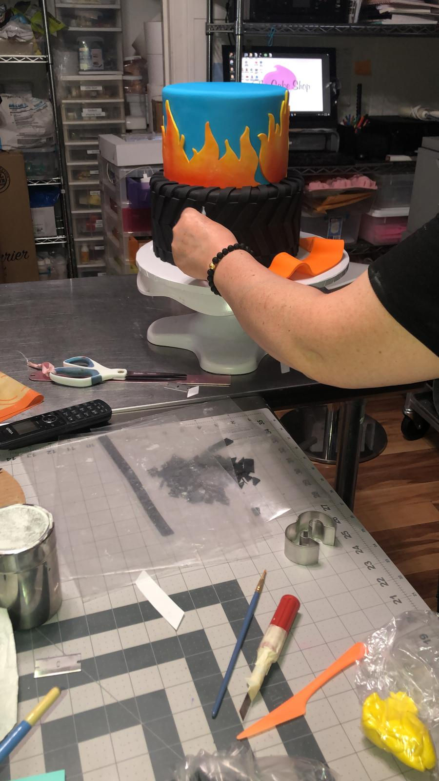 A cake being hand decorated in the shop