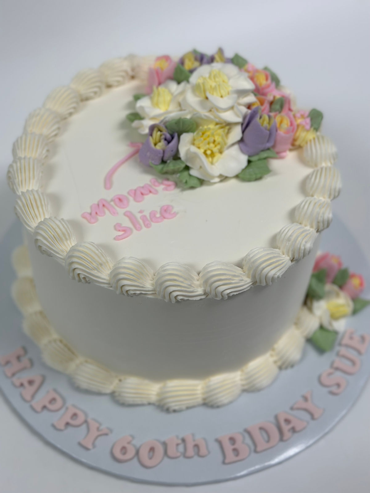 A white vintage cake decorated with sugar roses